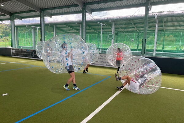 Menschen beim Bubble Soccer spielen in Freilufthalle