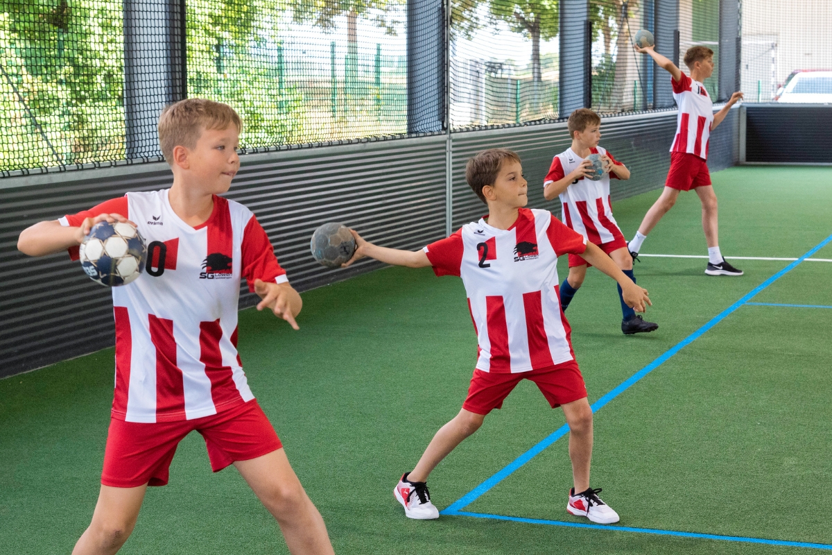 Kinder spielen Handball in Freilufthalle